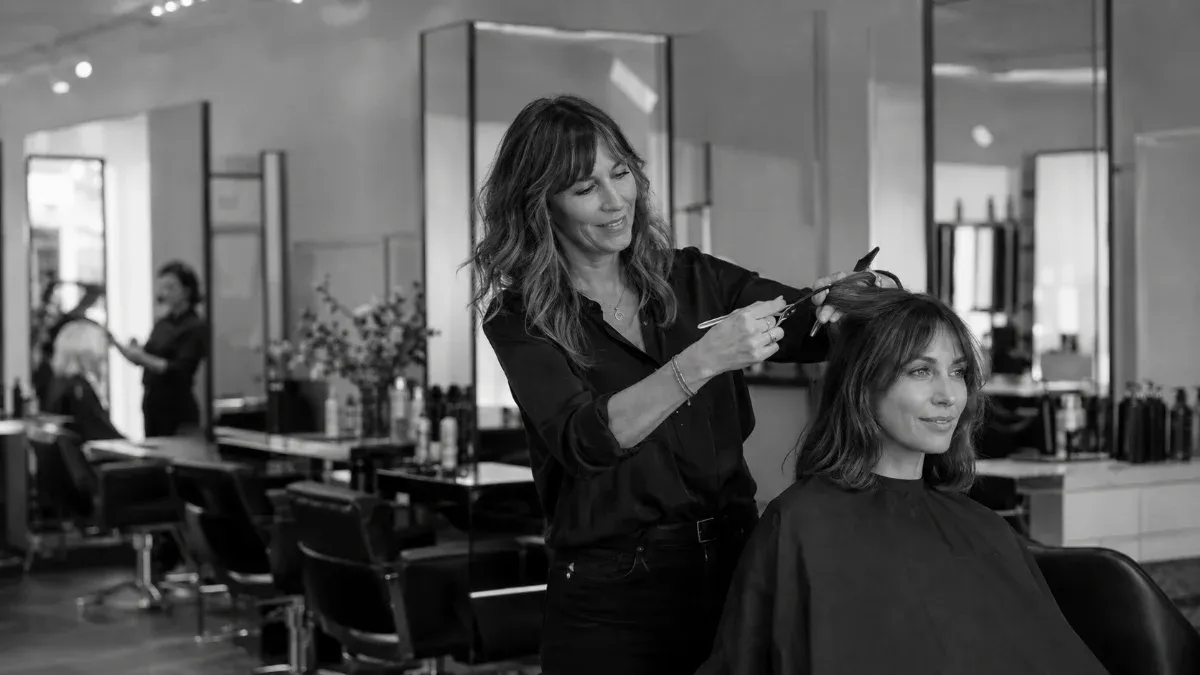 A salon floor mid-week: warm light, mirrors, and one empty chair