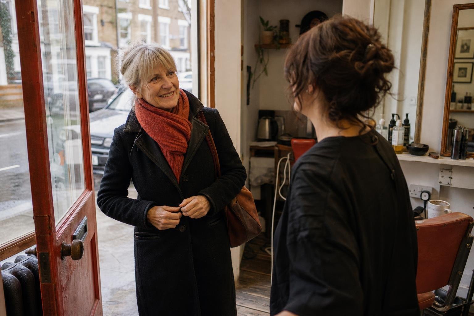 A stylist seeing a regular client out at the door, the sort of client a midweek salon discount only moves around