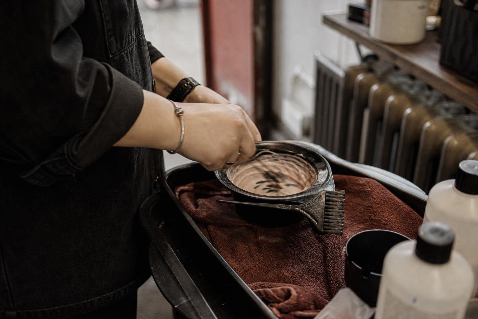A stylist mixing colour at the back of the salon, the kind of small salon budget Performance Max has to stretch across