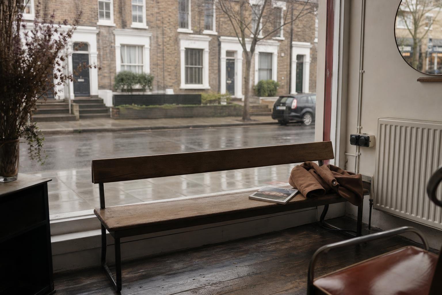 An empty waiting bench in a salon window on a wet afternoon, when salon ads bring in students, not paying clients